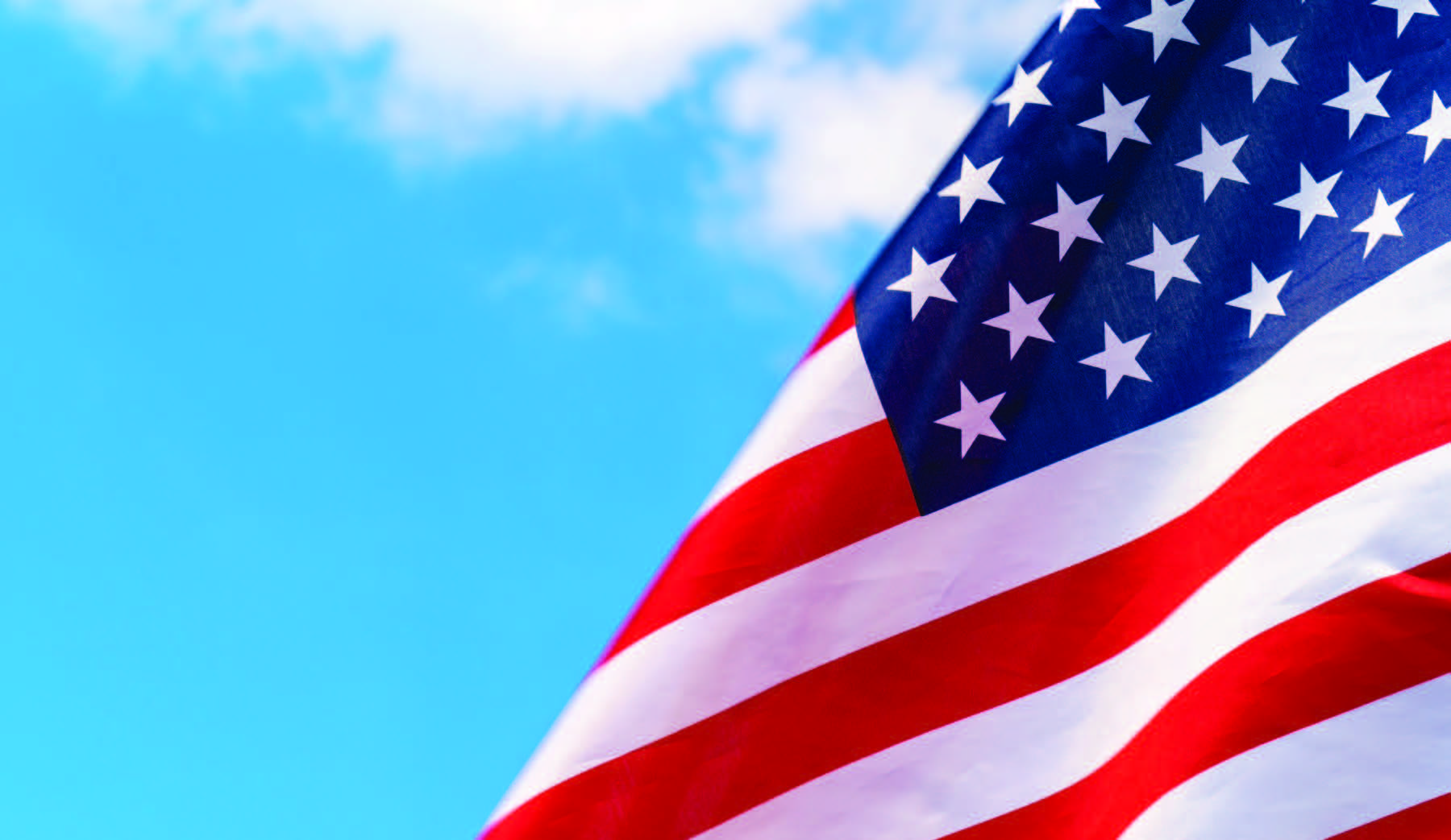 American flag waving against a blue sky